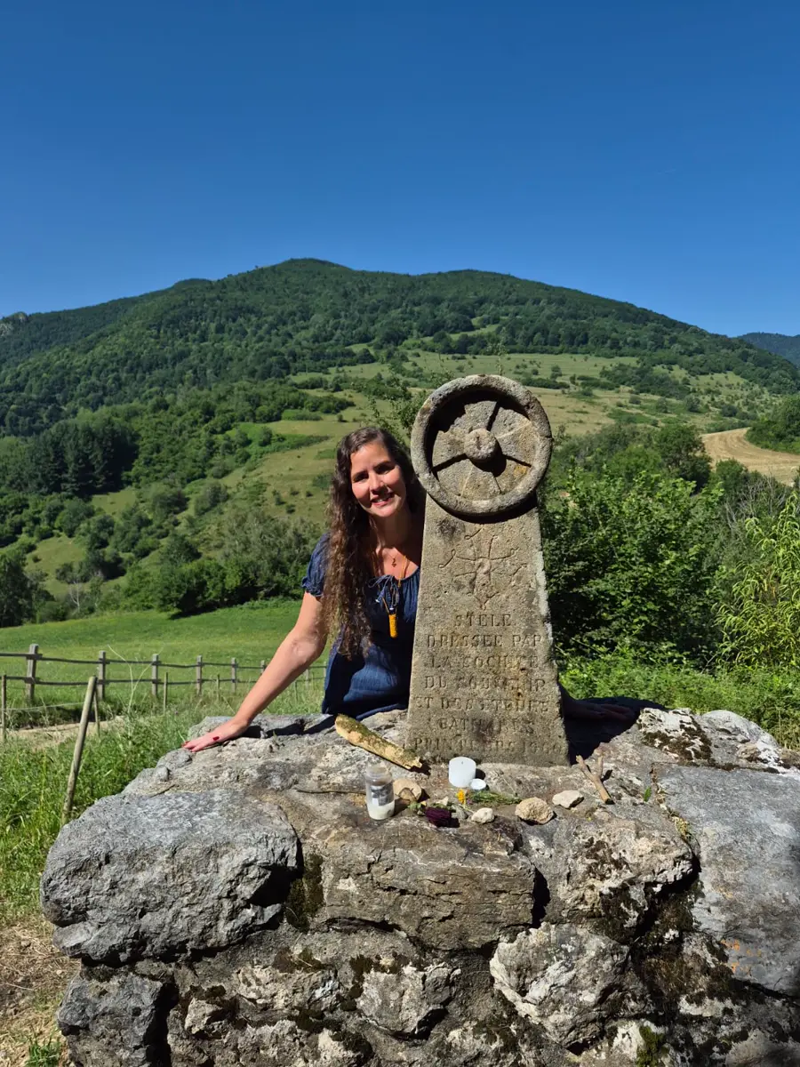 Hérica ao lado da estela cátara, com montanhas ao fundo